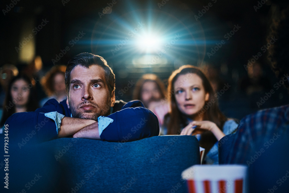 Young couple watching film in movie theater Young couple watching film in movie theater