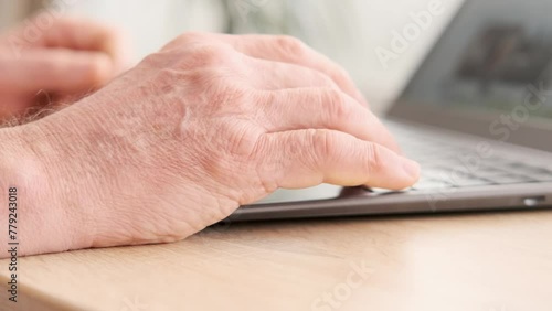 close-up mature male hands typing text on laptop keyboard, senior wellbeing, highlighting increasing digital literacy and empowerment of older adults, Typing Skills, Remote Work photo