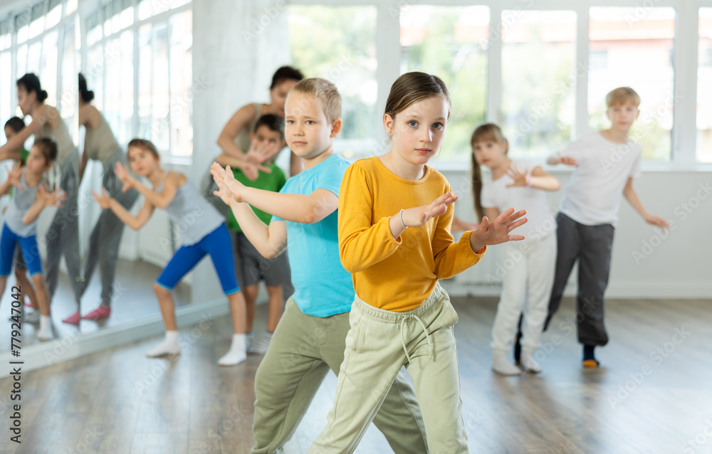 Naklejka premium Dance lesson for young children - girls and boys learn modern dances in pairs