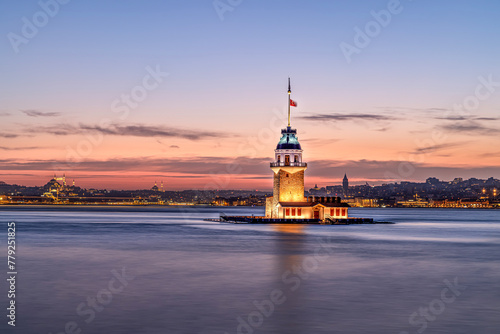 iery sunset over Bosphorus with famous Maiden's Tower (Kiz Kulesi) also known as Leander's Tower, symbol of Istanbul, Turkey. Scenic travel background for wallpaper or guide book photo