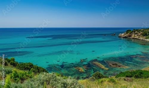 This stunning image captures the serene beauty of a coastal landscape with vivid turquoise waters meeting a lush green shoreline