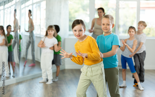 Group of children boys and girls dance energetic pair dance twist in studio