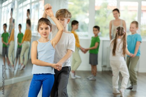 Children bachata dance group lesson in studio .Club for those who like to dance for their own pleasure, non-professional dance performers enjoy slow pair dance during rehearsal in studio