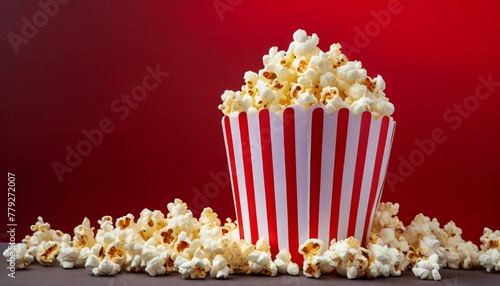Close-up of popcorn in a red and white packaging. Red background.

