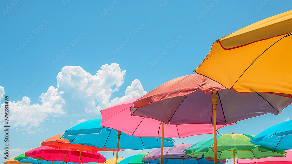 A colorful row of beach umbrellas providing shade on a sunny day.
