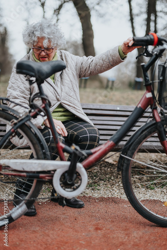 Joyful mature female retiree enjoying outdoor activities, taking a rest with her bike in a park setting.