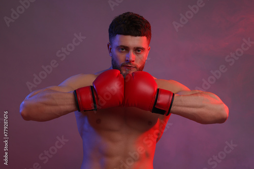 Man in boxing gloves on color background © New Africa