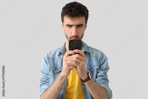 Confused young man using sm...