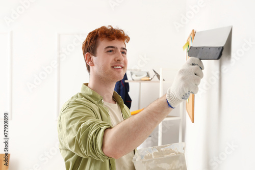Young man with putty knife ...