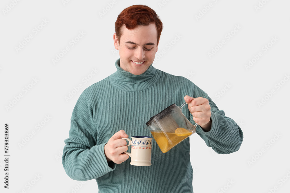 Young man pouring lemon tea into cup on white background Young man pouring lemon tea into cup on white background