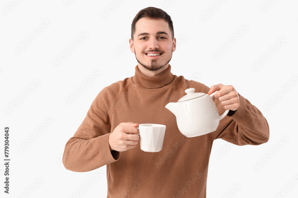 Young man pouring tea into cup on white background Young man pouring tea into cup on white background