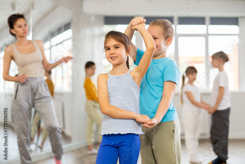 Children bachata dance group lesson in studio .Club for those who like to dance for their own pleasure, non-professional dance performers enjoy slow pair dance during rehearsal in studio