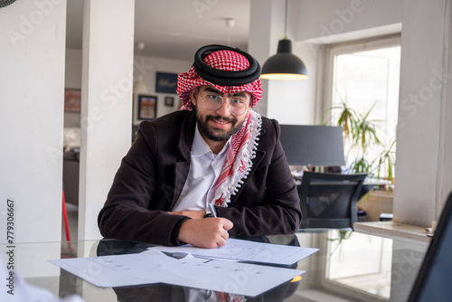 portrait for young arab male working in modern office with smile on his face photo