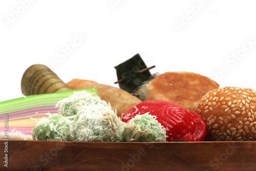 Close-up various kinds of Jajan Pasar, traditional Indonesian market snacks, on the wooden plate with banana leaves top view isolated on white background clipping path