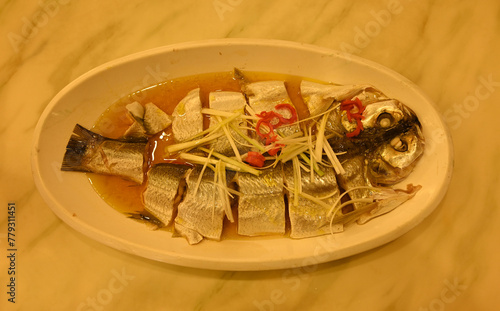 fresh steamed white fish with ginger and red pepper in the plate