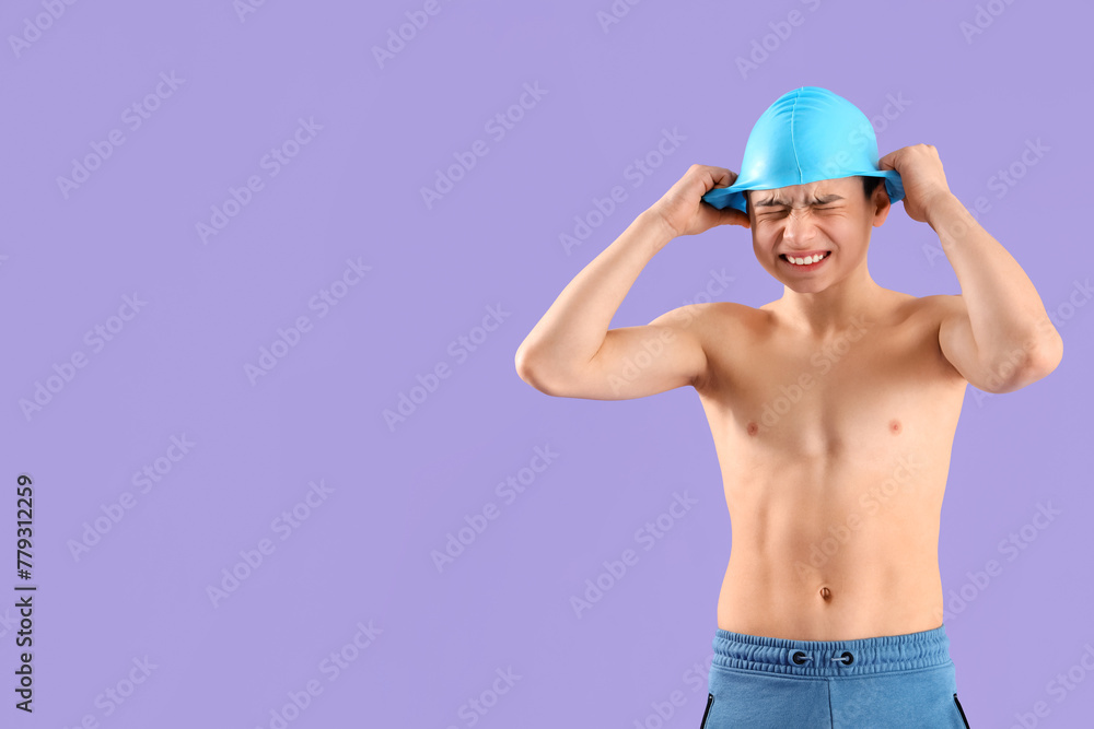 Angry little boy in swimming cap on purple background - obrazy, fototapety, plakaty 