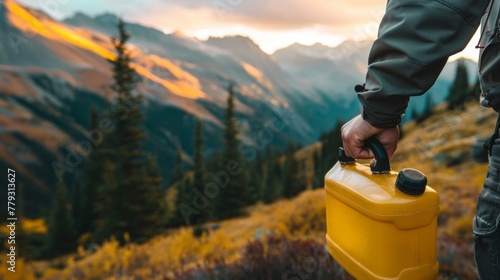 A closeup shot of a hand holding a container filled with biodiesel with a backdrop of mountainous terrain in the background. The caption reads The backcountry community embraces ecofriendly . photo
