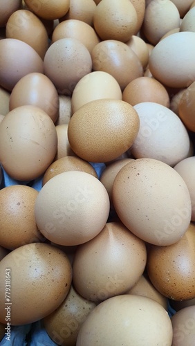 Close up of randomly stacked chicken eggs sold at the market as a background. 