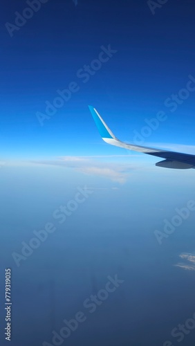 Looking through window aircraft during flight in wing with a nice blue sky clouds.