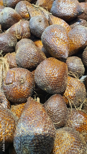 Close up of a pile of snake fruit being sold at the market in the background.
