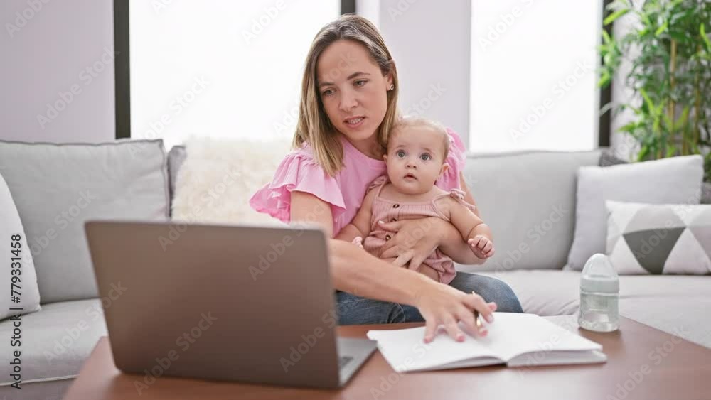 At home, a lovely mother and daughter sitting on the sofa, engrossed in a serious video call conversation, taking notes while telecommuting. At home, a lovely mother and daughter sitting on the sofa, engrossed in a serious video call conversation, taking notes while telecommuting.