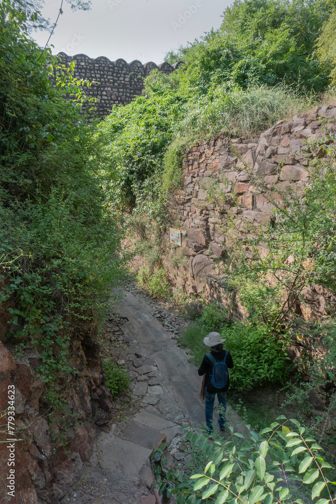 Female solo Indian tourist at Hathi nahar, Elephant gully or Rainwater gully to channel rainwater to lakes of Mehrangarh fort, at Rao Jodha Desert Rock Park, Jodhpur, Rajasthan, India. Solo tourism.