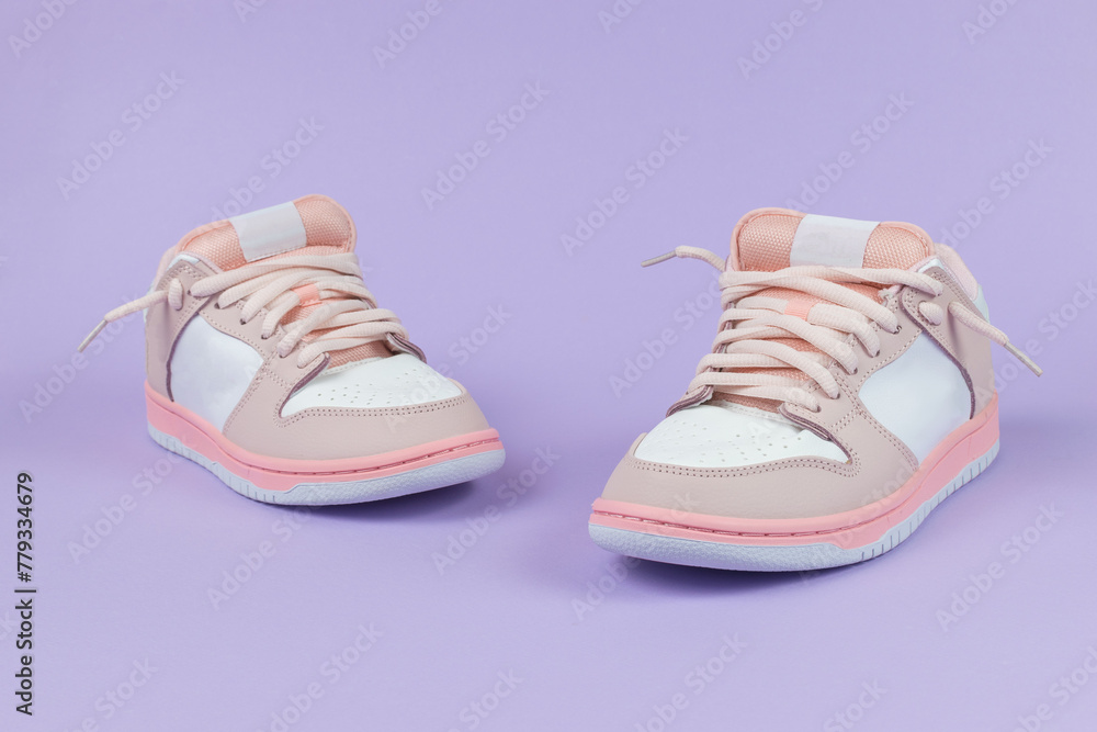 Sneakers are pink and white on a purple background. Sneakers are pink and white on a purple background.