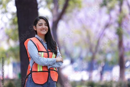 mexican working woman engineer smiling in the park, looking at the camera