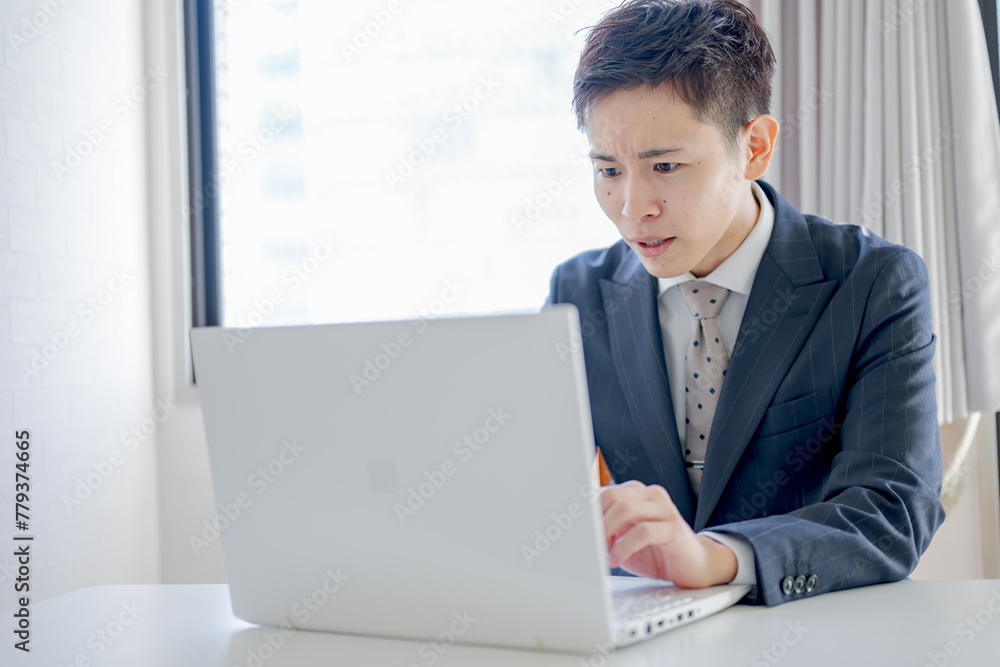 顔をこわばらせるスーツ男性 顔をこわばらせるスーツ男性