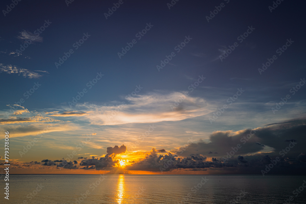 Sunset on tropical beach sea ocean with sunrise clouds. Banner for travel vacation. Scenery sky and reflection rays in water. Beach sunrise over the tropical sea. Tranquil, golden sky background. Sunset on tropical beach sea ocean with sunrise clouds. Banner for travel vacation. Scenery sky and reflection rays in water. Beach sunrise over the tropical sea. Tranquil, golden sky background.