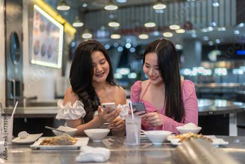 Two asian women selecting food   elegant restaurant  deeply engrossed in selecting meals from gourmet menu  lifestyle  leisure  luxury dining  female friendship  discussing sharing recommendation