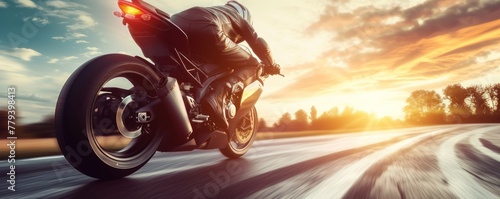 Motorbike rider in sunset light riding with high speed against motion blured background © Daniela