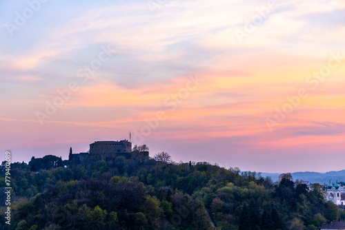 Gorizia Castle seen from the top of the hill over Nova-Gorica in Slovenia. Quiet day, relaxing places in the greenery, panorama with sunset and warm-colored clouds. Cultural Heritage Capital 2025.