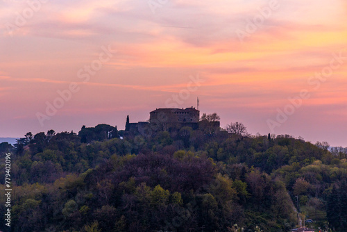 Gorizia Castle seen from the top of the hill over Nova-Gorica in Slovenia. Quiet day  relaxing places in the greenery  panorama with sunset and warm-colored clouds. Cultural Heritage Capital 2025.