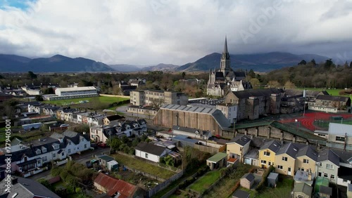 rising cinematic drone shot Killarney Ireland St Mary's Cathedral with national park mountains in background photo