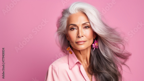 Elegant, elderly, chic Latino, Spain woman with gray long hair and perfect skin, pink background, banner.