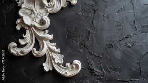 White ornamental plaster molding detail on black background.