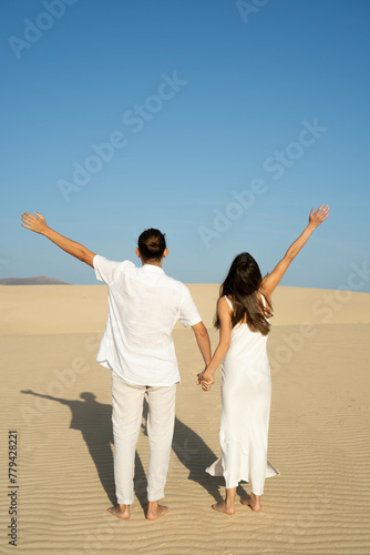 Young man and woman holding hands backwards and raising arm as freedom symbol.