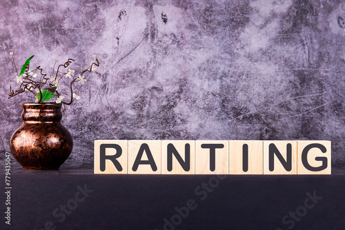 RANTING word made with wooden building blocks on a grey background photo