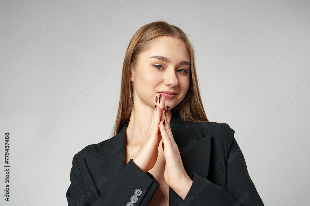 Young Woman in Black Jacket Posing to Camera against gray background Young Woman in Black Jacket Posing to Camera against gray background