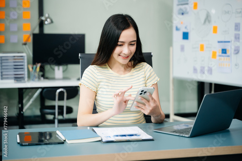 Asian businesswoman working with working notepad, tablet and laptop documents talking on the smartphone, tablet and laptop video call tax