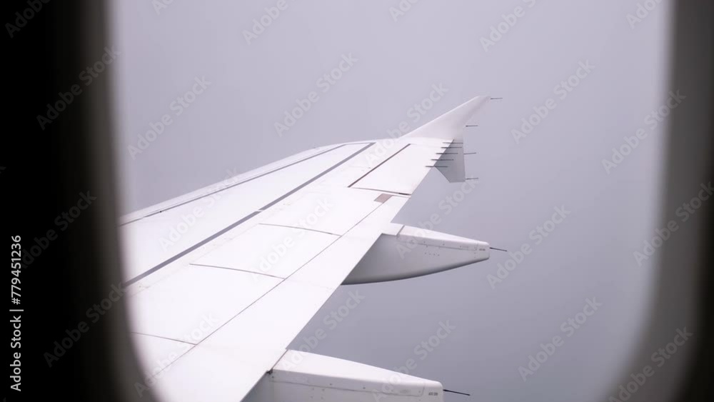 Turbulence zone. View on an airplane wing in clouds through a porthole. Cloudy sky. A passenger plane flying in fog. Bad weather. Low visibility. Concept of people's fear traveling by air. Aerophobia Turbulence zone. View on an airplane wing in clouds through a porthole. Cloudy sky. A passenger plane flying in fog. Bad weather. Low visibility. Concept of people's fear traveling by air. Aerophobia