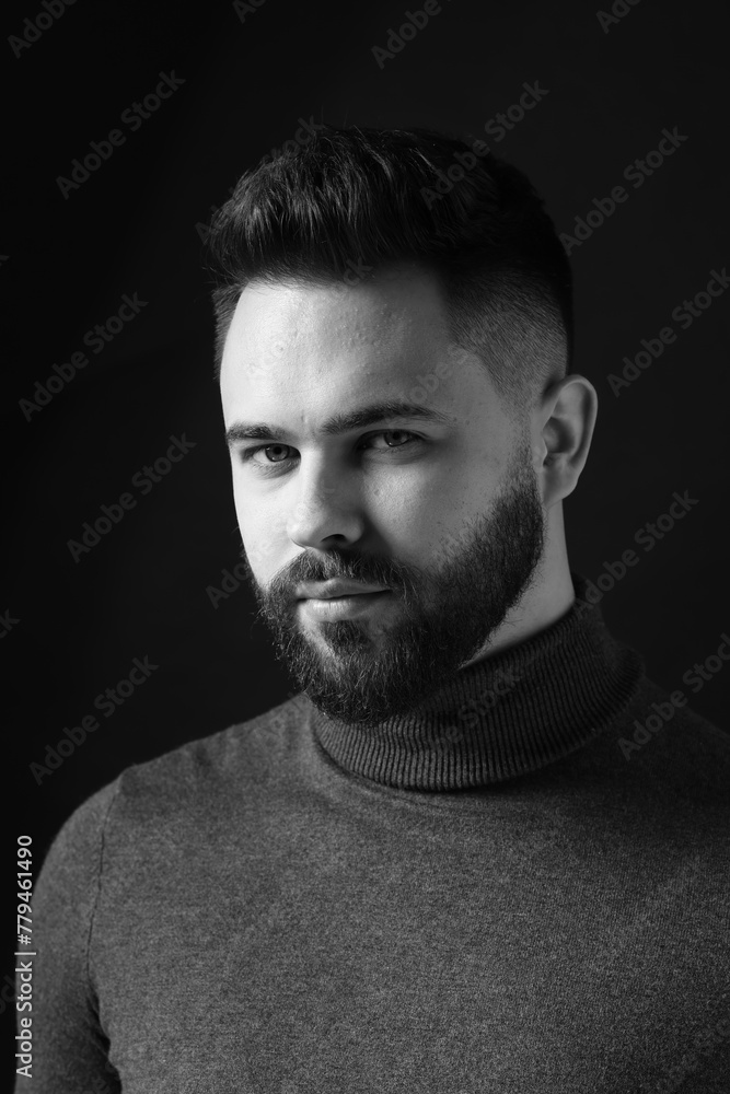 Portrait of handsome bearded man on dark background. Black and white effect