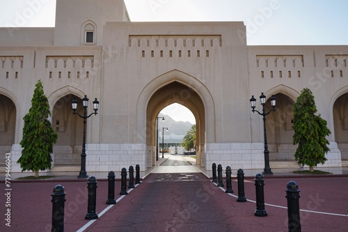 Mountain sunset landscape peaking through a traditional Arabian archway at Al Alam Palace in Muscat, Oman