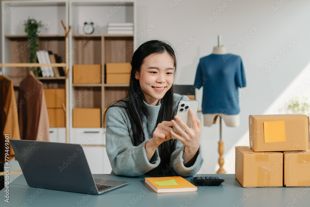 Successful fashion designer. Attractive woman with smile while standing in workshop. Beautiful owner woman working and holds tablet, laptop Successful fashion designer. Attractive woman with smile while standing in workshop. Beautiful owner woman working and holds tablet, laptop