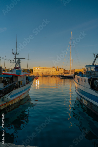 Vista panoramica sul porto di Trani al tramonto con barche e pescherecci di pescatori. Puglia, Italia.