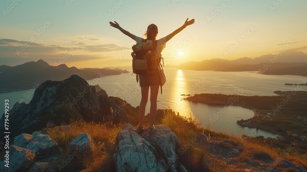 Woman with backpack standing on a mountain at sunset, arms raised in victory. Woman with backpack standing on a mountain at sunset, arms raised in victory.