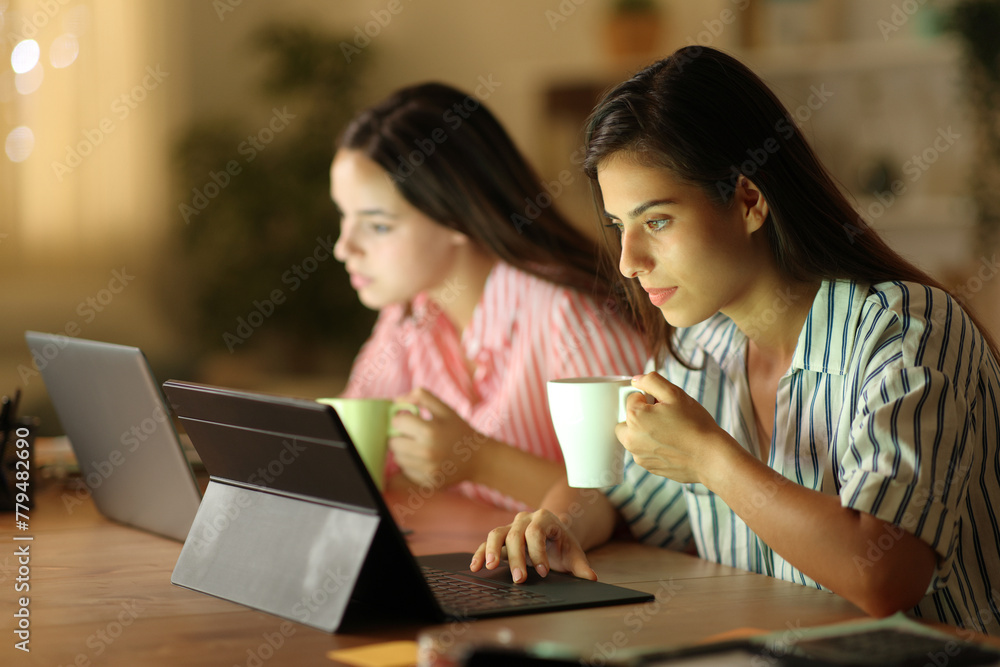 Two tele workers drinking and working online in the night Two tele workers drinking and working online in the night