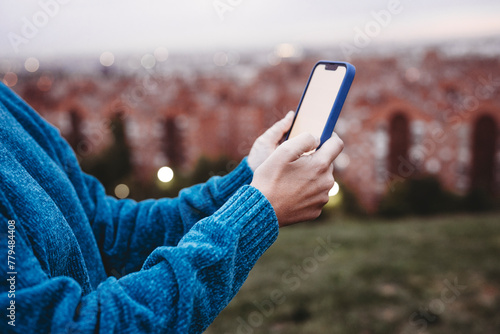 Woman using smart phone at sunset photo