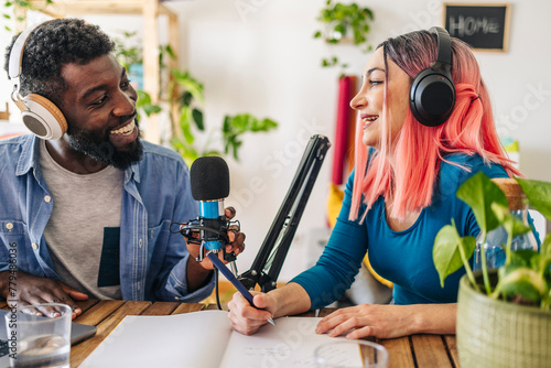Happy influencers recording podcast together at home photo